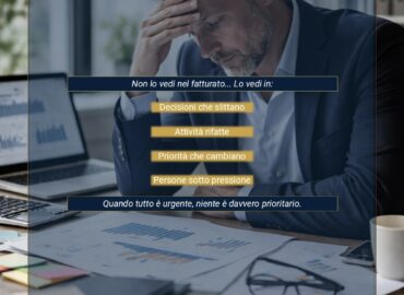 Il costo invisibile Imprenditore sotto pressione tra report e documenti, simbolo del costo invisibile generato da mancanza di regia e governance operativa.